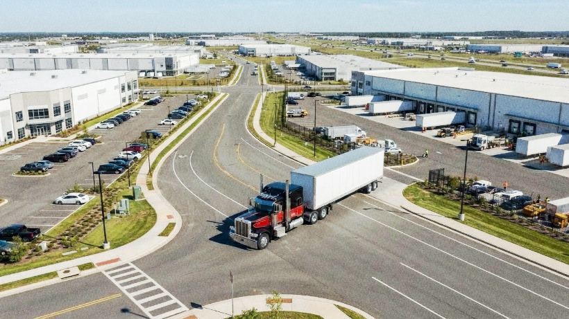 Truck driver using a mobile phone beside a semi-truck.
